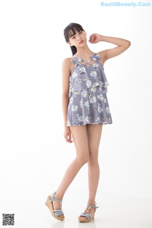 A woman wearing a gray and white floral romper.
