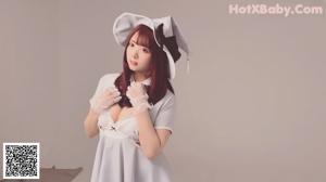 A woman in a maid outfit is posing for a picture.