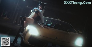 A woman in a cat costume leaning on a car.