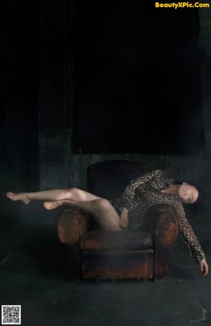 A woman sitting on a chair in front of a window.