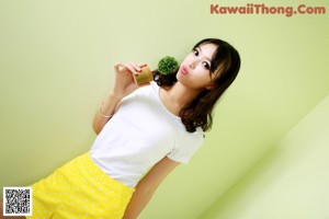 A woman in a white shirt and yellow polka dot shorts.