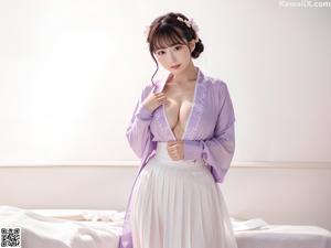 a woman in a pink robe is posing for the camera