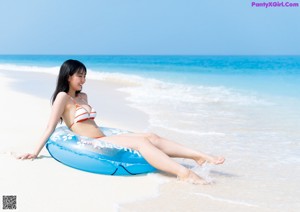 A woman in a white bathing suit standing in a field of flowers.